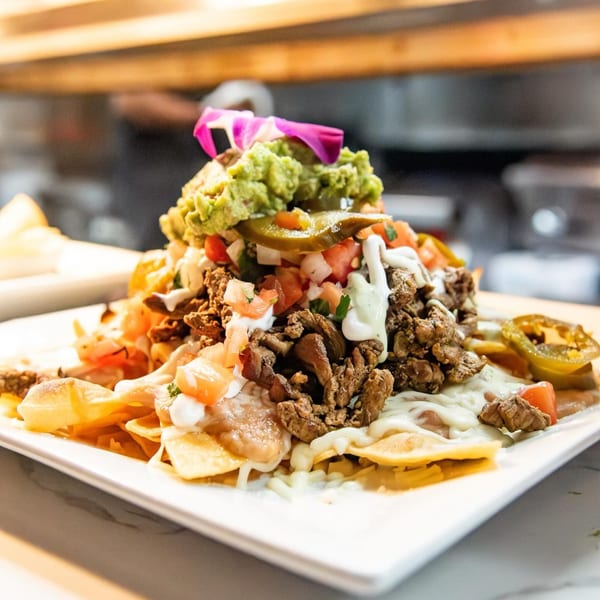 Loaded California Tacos Cantina nachos with steak, guacamole, pico de gallo, and jalapeños.